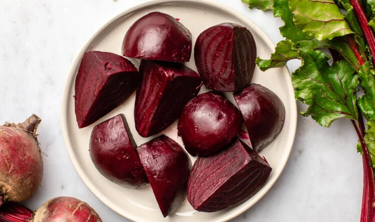 Freshly cooked and peeled beets cut into chunks on a plate, a natural ingredient found in supplements for liver health.