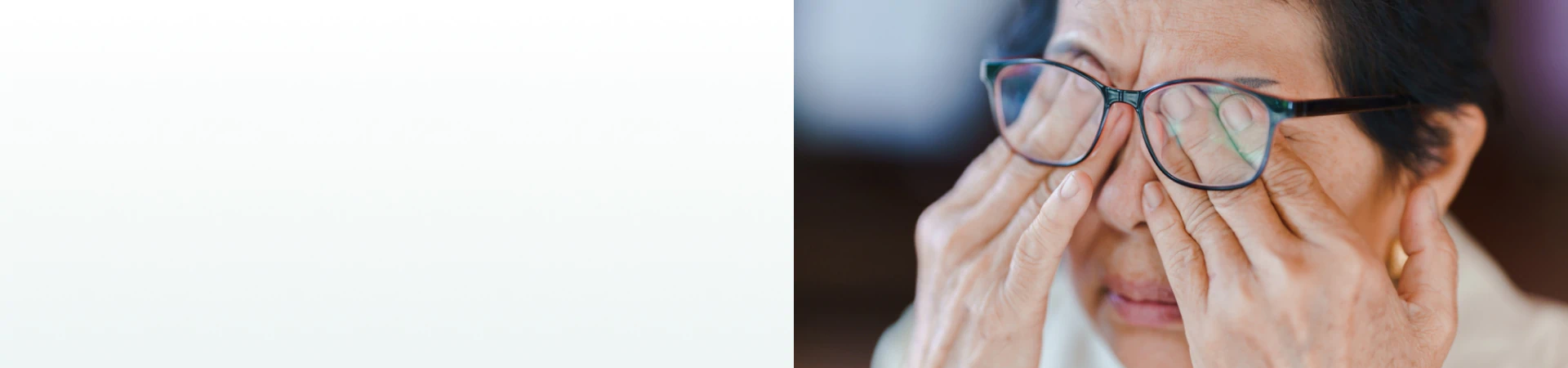 An elderly woman rubbing her eyes while wearing glasses, representing the need for supplements for vision support.
