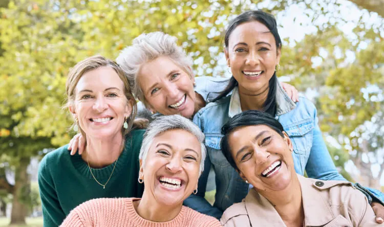 A group of happy, healthy women enjoying time together outdoors, representing vitality supported by supplements for women's health.